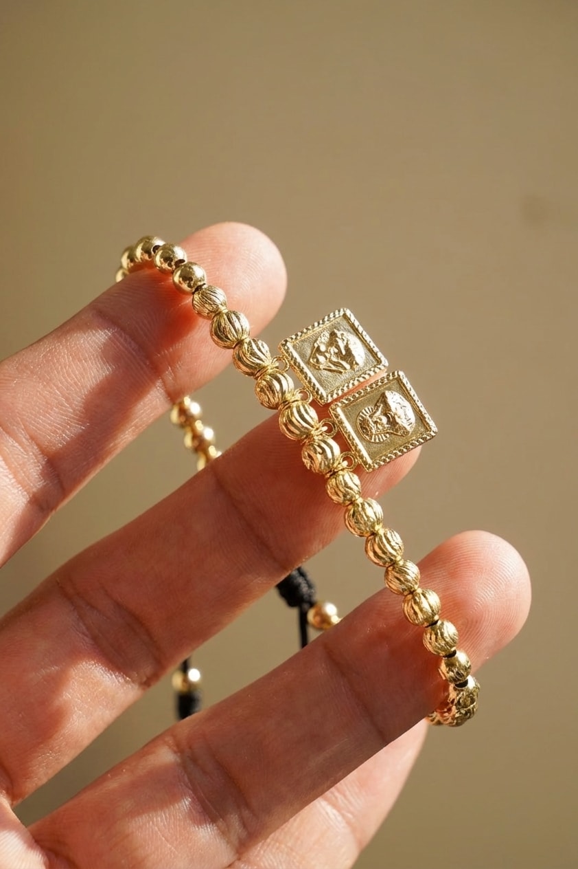 Pulsera Escapulario Italiano detalle macro sostenida entre dedos en oro laminado 18k NJL Jewelry