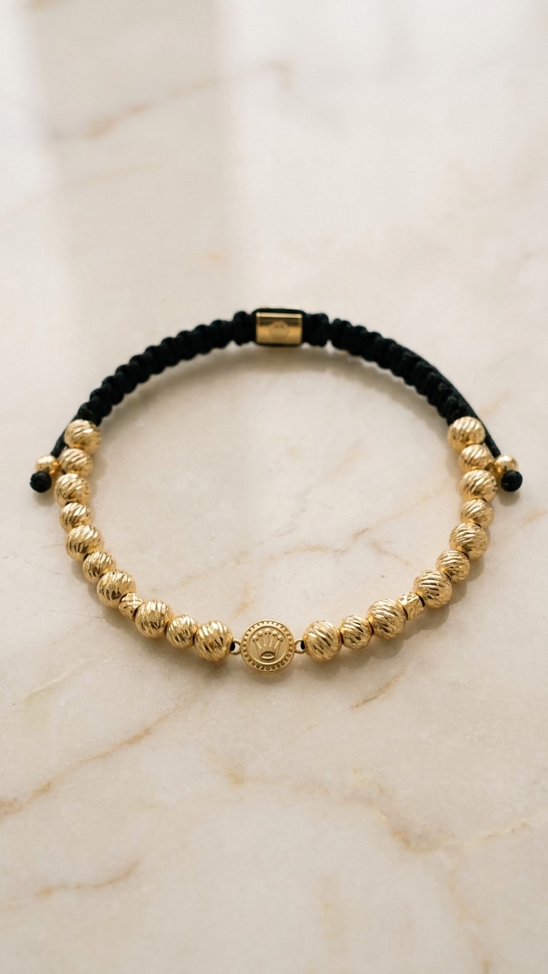 Pulsera balines diamantados con medalla central oro laminado 18k flat lay sobre mármol cremoso, composición elegante NJL Jewelry