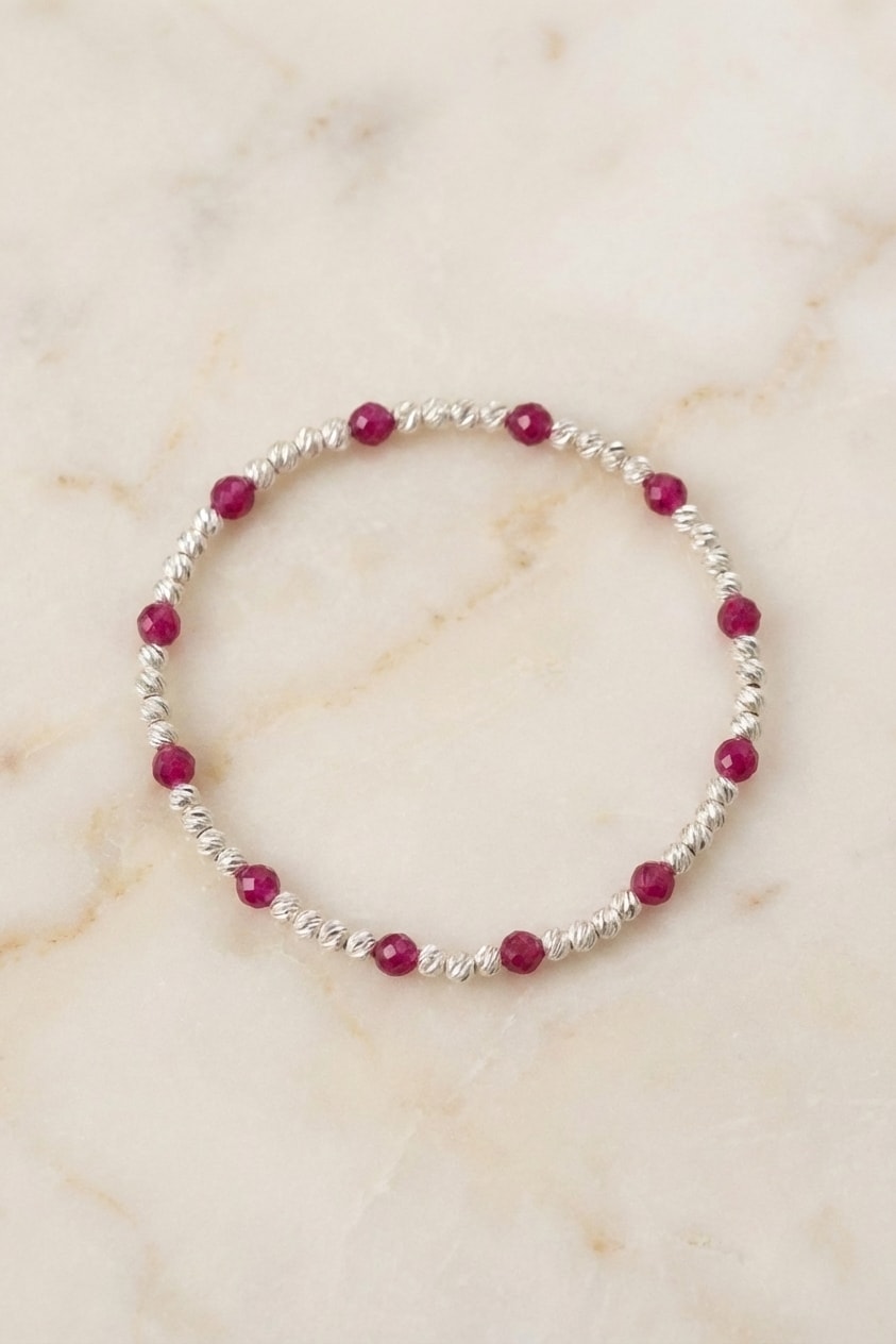 Pulsera Plata 925 con Rubí 3mm flat lay sobre mármol cremoso, composición elegante en oro laminado 18k NJL Jewelry