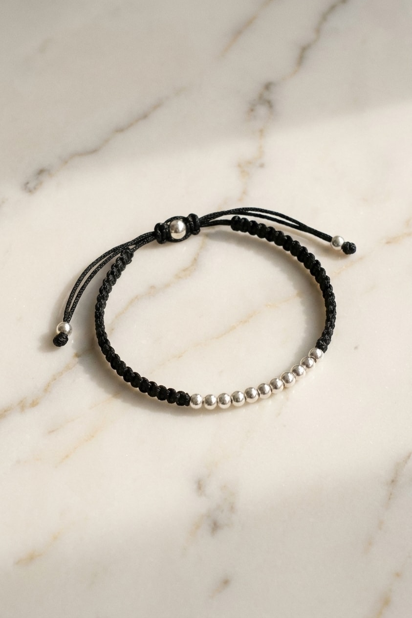 Pulsera Trenza Bicolor 4mm flat lay sobre mármol cremoso, composición elegante en oro laminado 18k NJL Jewelry