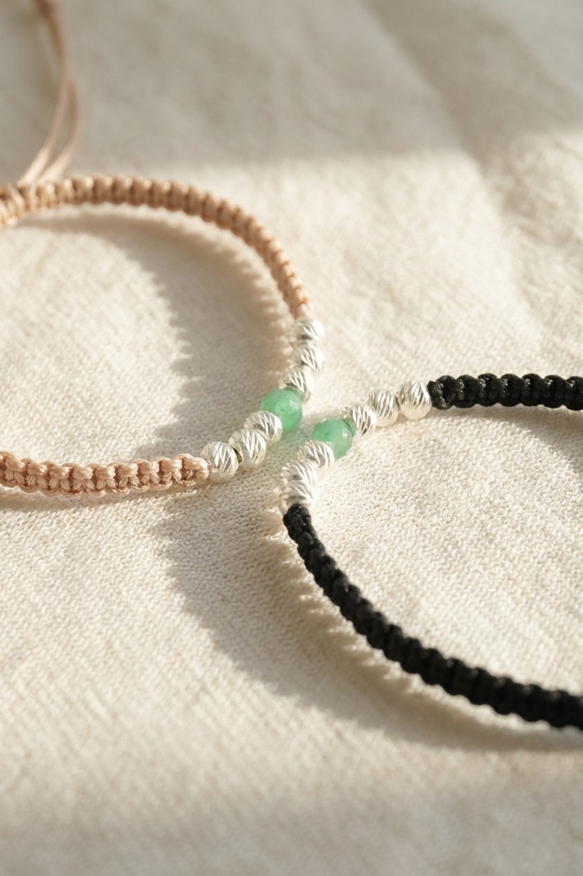 Pulsera Vida Esmeralda sobre lino cremoso, flat lay editorial en oro laminado 18k NJL Jewelry