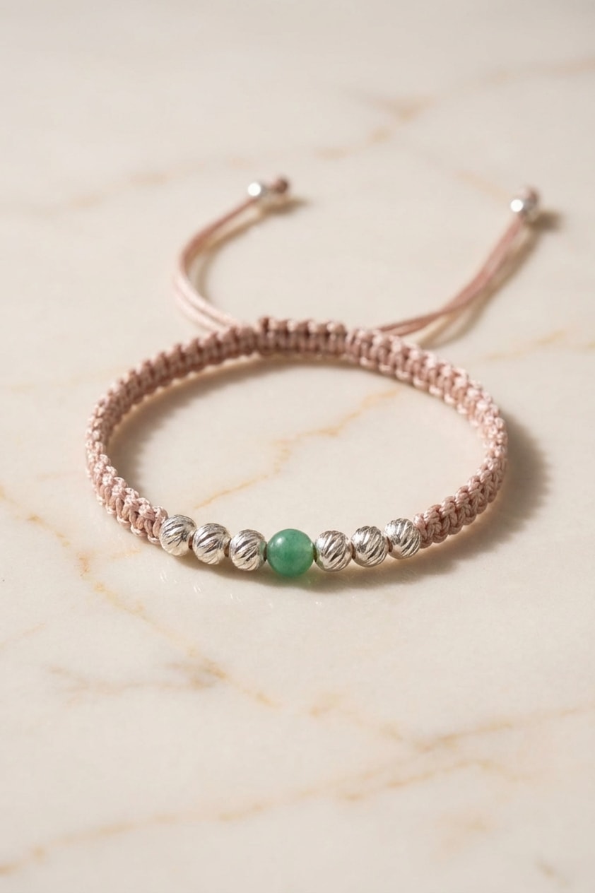 Pulsera Vida Esmeralda flat lay sobre mármol cremoso, composición elegante en oro laminado 18k NJL Jewelry