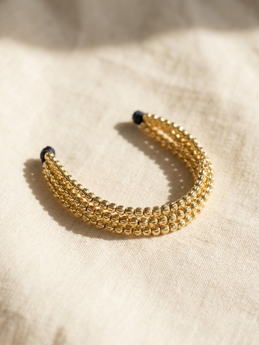 Set de 3 pulseras finas con balines mini diamantados oro laminado 18k sobre lino crema, flat lay editorial NJL Jewelry