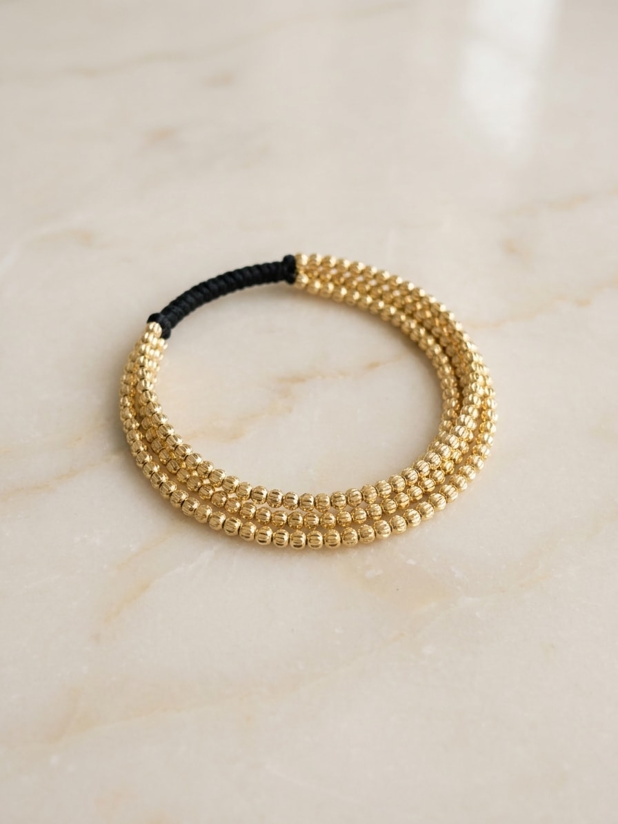 Set de 3 pulseras finas con balines mini diamantados oro laminado 18k flat lay sobre mármol cremoso, composición elegante NJL Jewelry